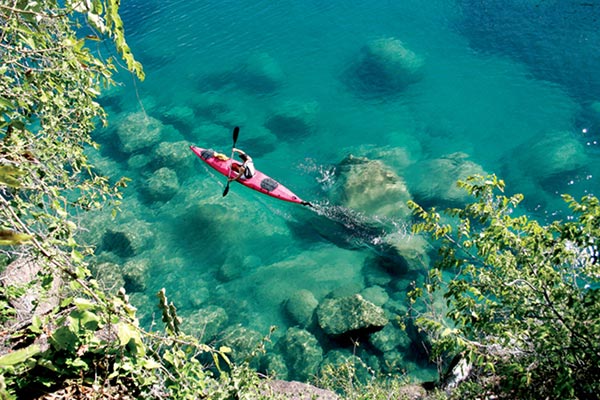 Marine safaris Lake Malawi kayaking through clear blue waters. Luxury African safari.