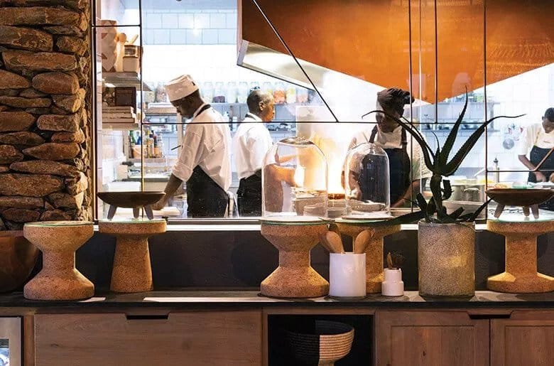 Chefs work in the interactive kitchen at Singita Faru Faru