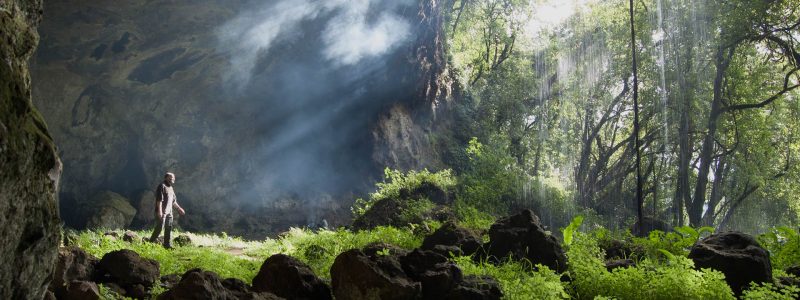 Ugandan scenery magnificent waterfall surrounded by caves and lush green forest. Luxury African safari.