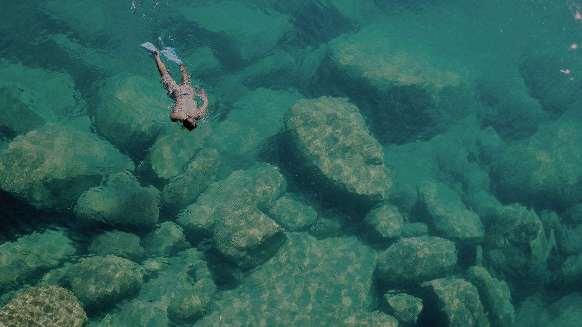 Lake Malawi Majete man snorkeling in clear light blue waters. Luxury African Safari.
