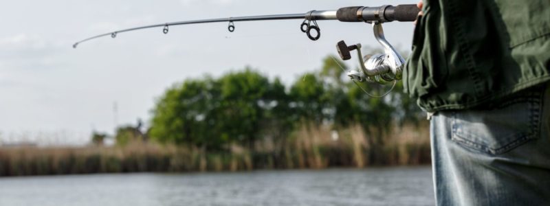 Fisherman with spinning on the river background