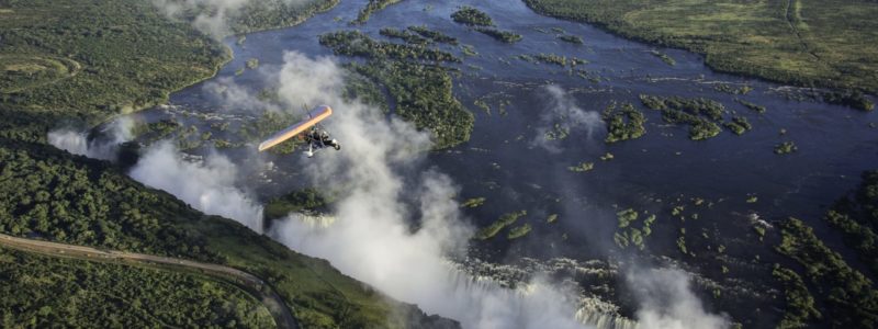 Fly over safari of Zambia, view of huge rivers, green vegetation through the clouds.