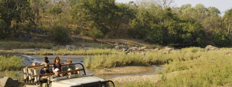 People on jeep safari tour through Malawi landscape. Luxury African safariu.