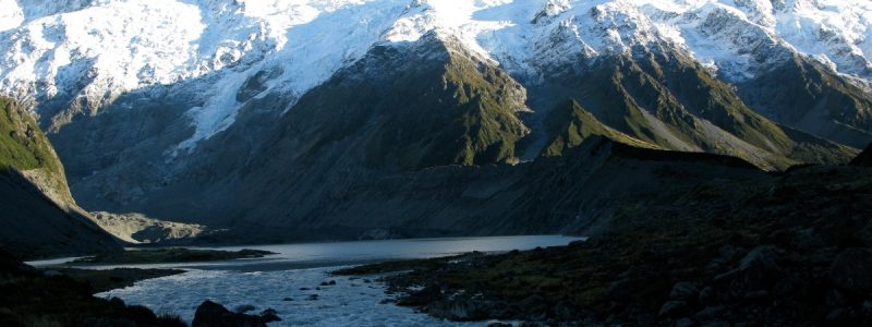 Rwenzori Mountain Ranges rock to snow top, with running river below. Luxury African safari.