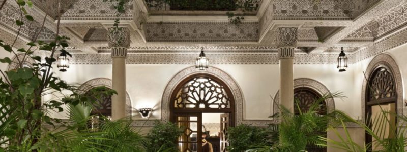 Luxury exterior villa view from courtyard, with African style fountain and vegetation