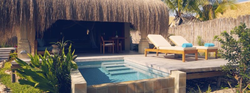 Azura Benguerra luxury villa with stunning decking and pool area outside traditional African villa exterior. Surrounded by beautiful African landscapes.