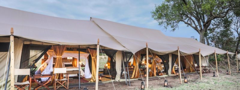 Spacious and well-furnished safari tent with open sides and canopy, set up at Legendary Expeditions in Tanzania.