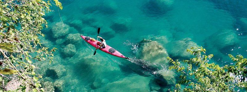 Marine safaris Lake Malawi kayaking through clear blue waters. Luxury African safari.