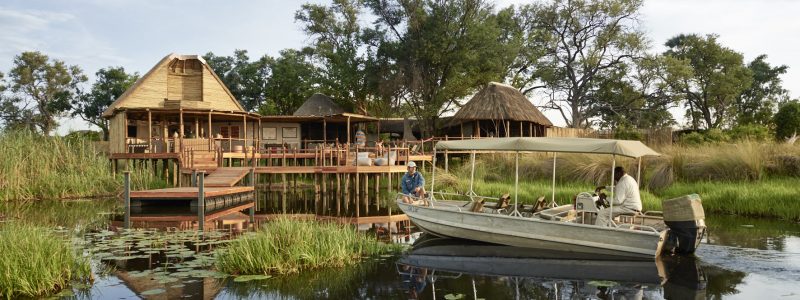 Sanctuary Retreats - Baines' Camp, Okavango Delta, Botswana. Boat trip to lodge over African river.