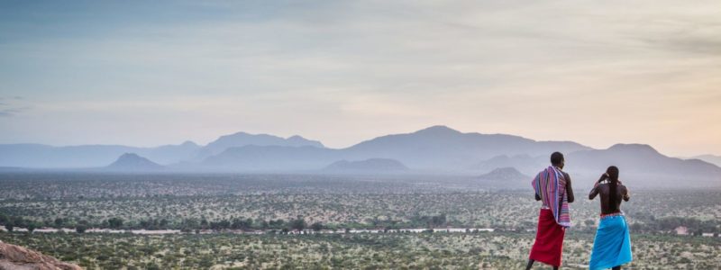 Sasaab Samburu Kenya locals in cultural clothing overlooking beautiful Kenyan mountains and landscape.