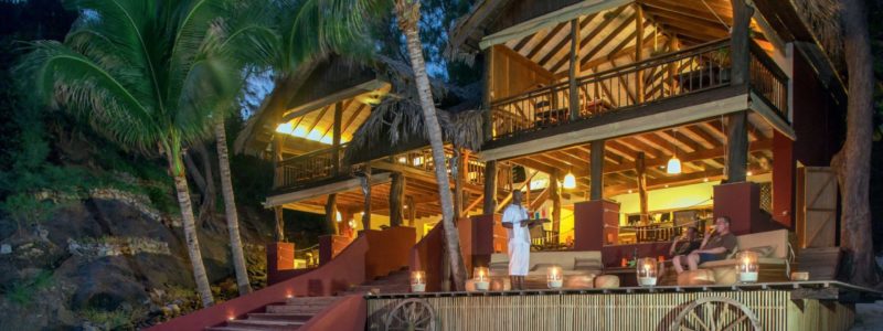 Tsarabanjina Madagascar Restaurant on white sands. Surrounded by green palm trees. Luxury African safari.