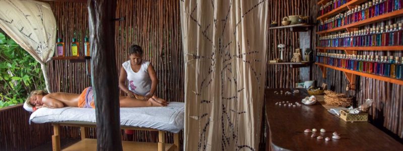 Man receiving spa massage in Tsarabanjina Madagascar hut. Luxury African safari.