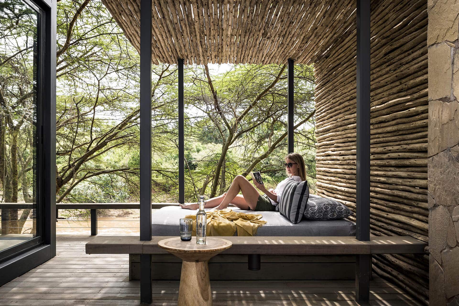 Female solo traveler relaxing at Sanctuary Olonana Camp which is one of the masai mara safari lodges