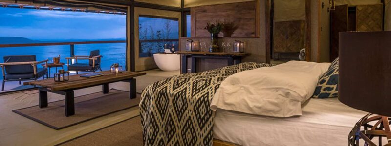 Luxury Kenya Safari The Cliff Bedroom With African style furniture overlooking clear blue African ocean and cliffs.