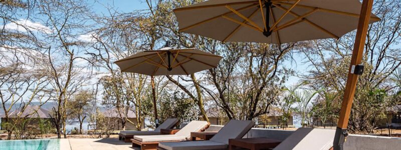 Luxury Kenya Safari The Cliff Poolside and decking are with African trees and ocean in the background.