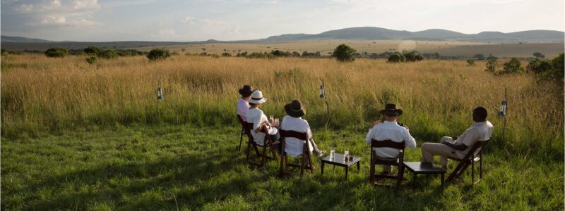 Sun gazing with refreshments and tour guides in Kenyan landscape on African safari.