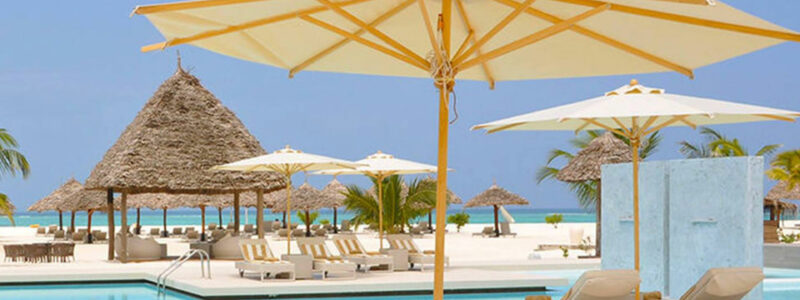 The ocean and beach at Gold Zanzibar. With pool and decking area next to white sands.