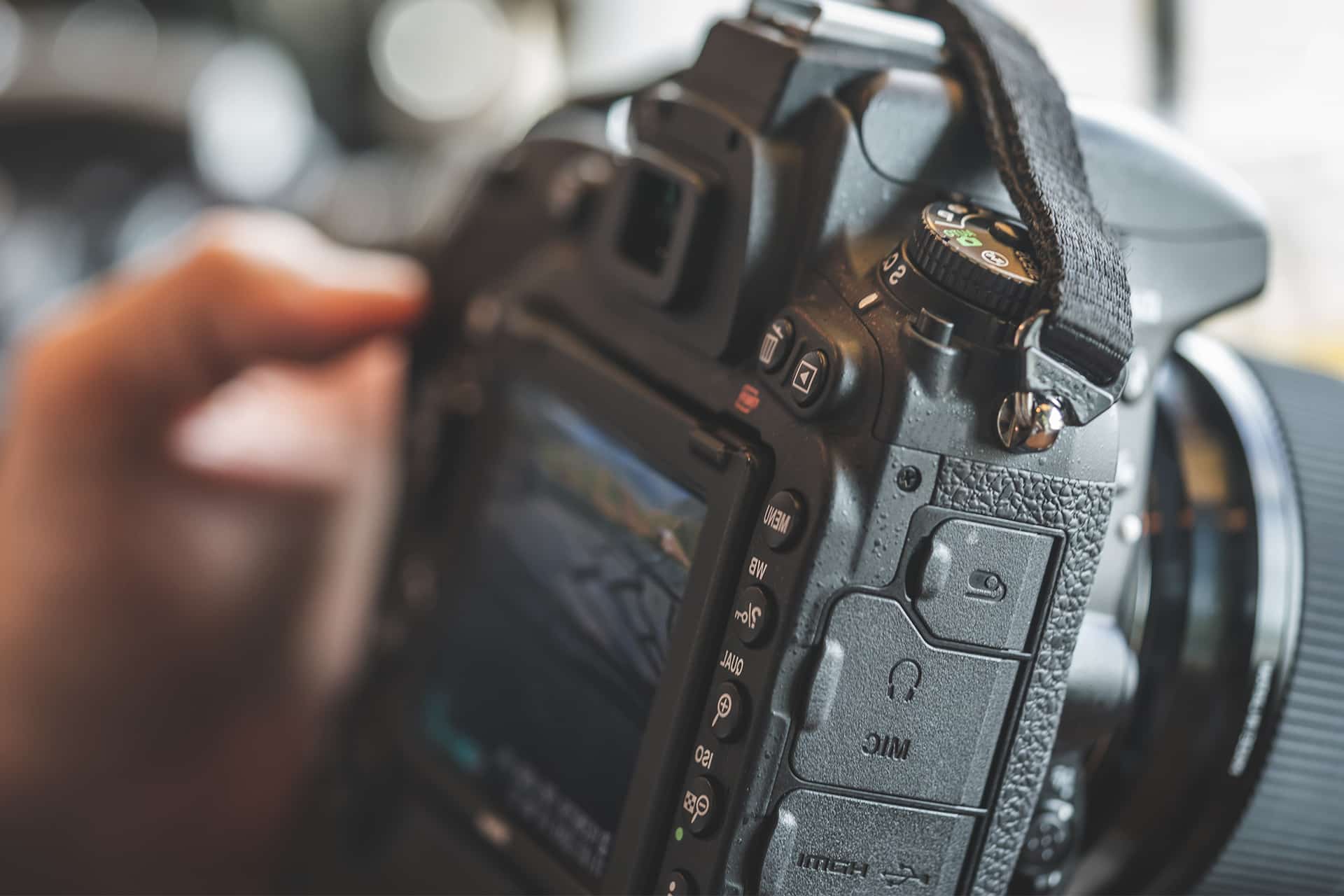 Close-up of a DSLR camera in hand, capturing a safari scene on the screen, ideal for documenting wildlife and landscapes on a tailored photographic safari.