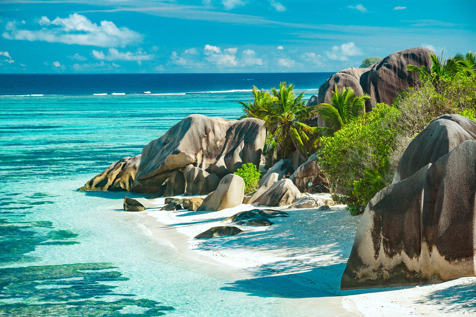 Pristine tropical beach in Seychelles with dramatic granite boulders, lush rainforests, and turquoise waters, perfect for a luxury island getaway.