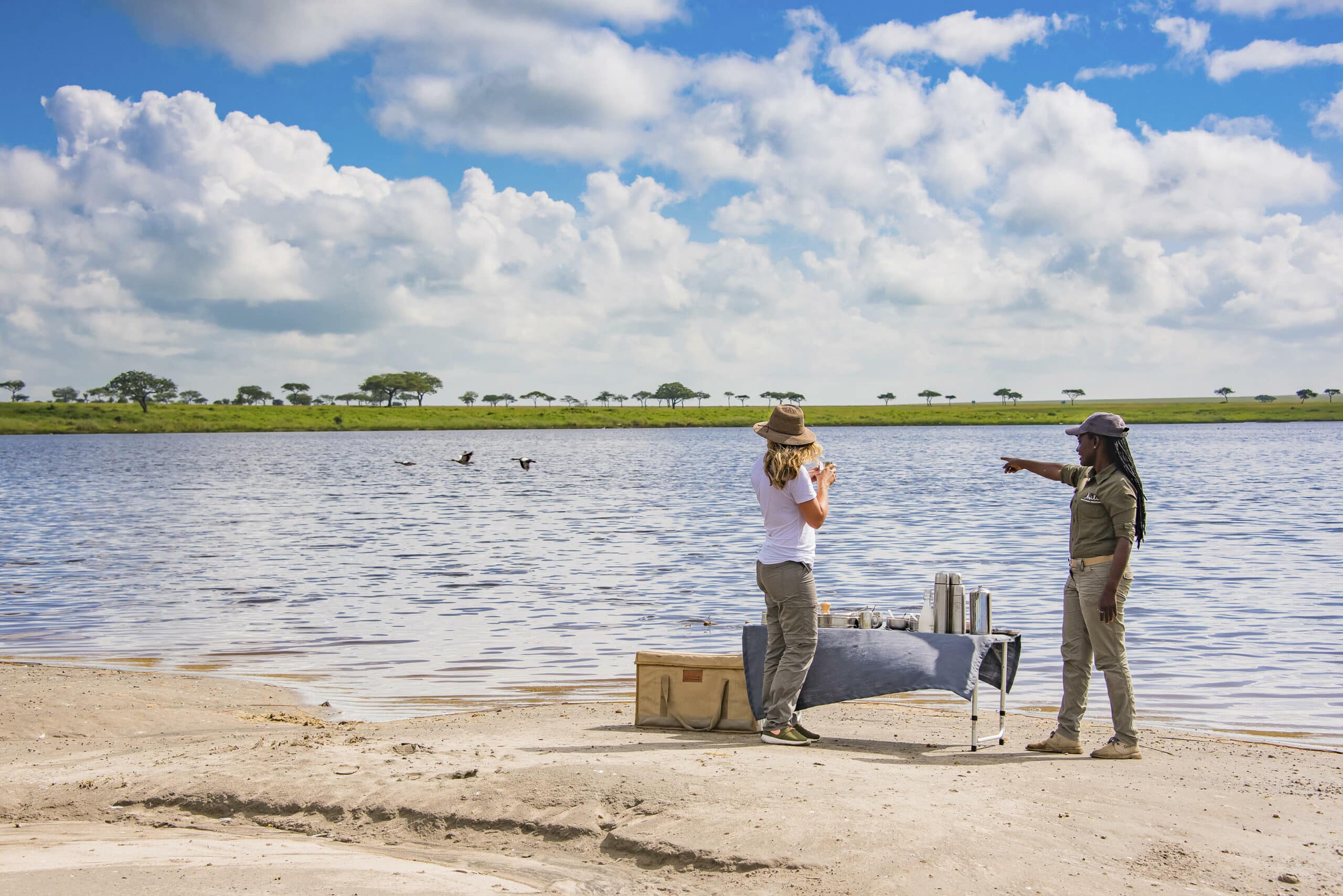 Two women standing near water at Dunia Camp
