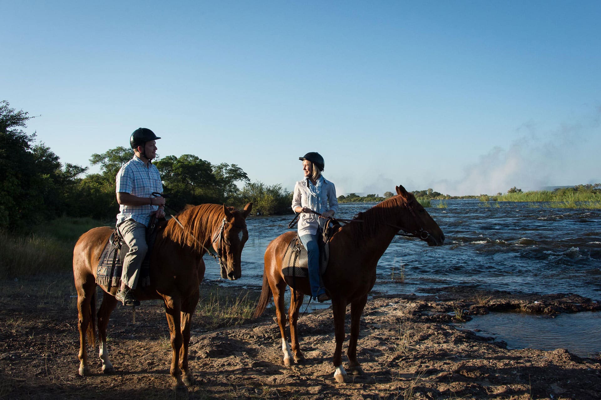 A man and a woman on an African horseback safari at Royal Chundu Island Lodge