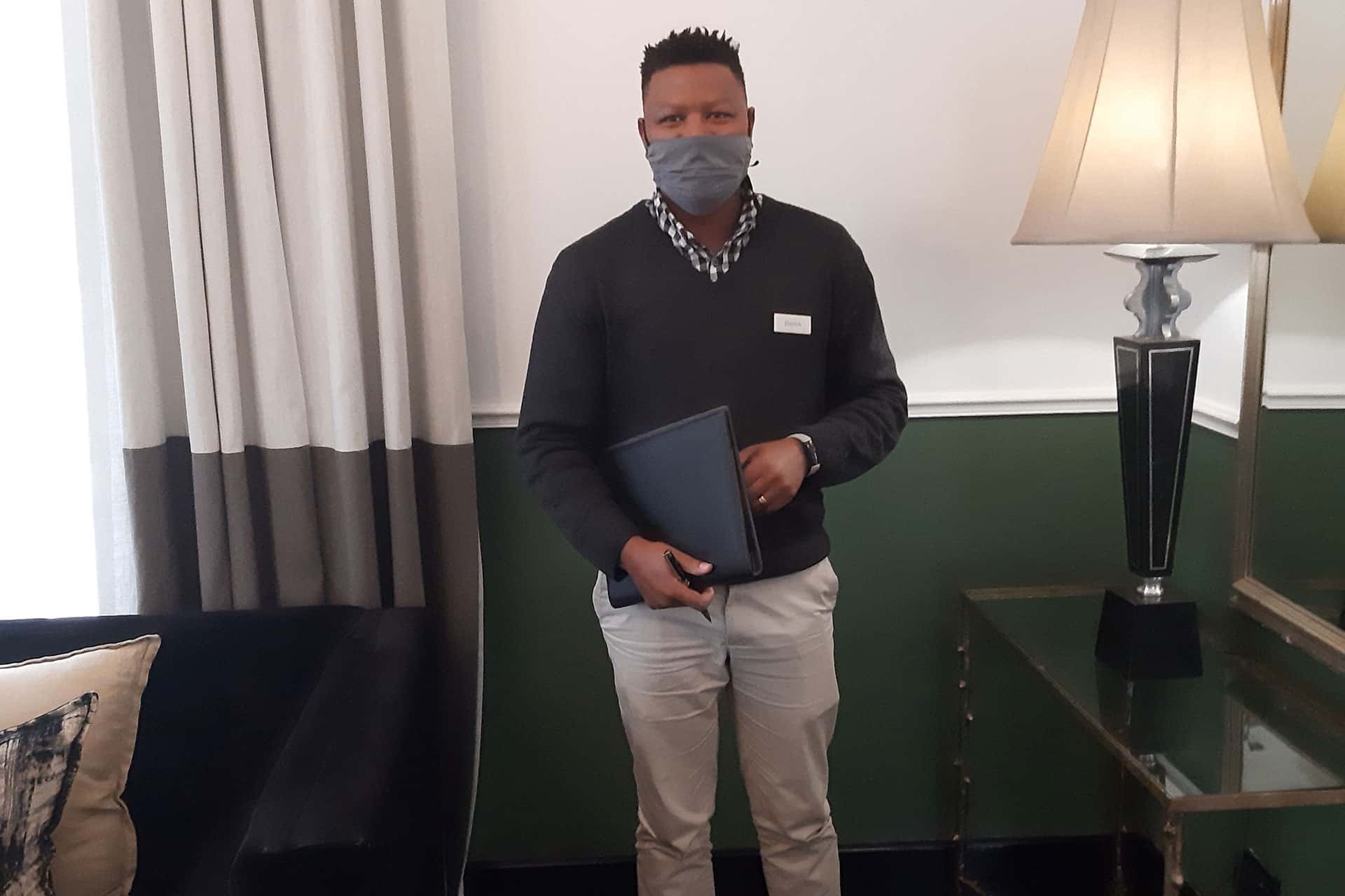 A male staff member stands in the hotel lobby at the Cape Cadogan Boutique Hotel.