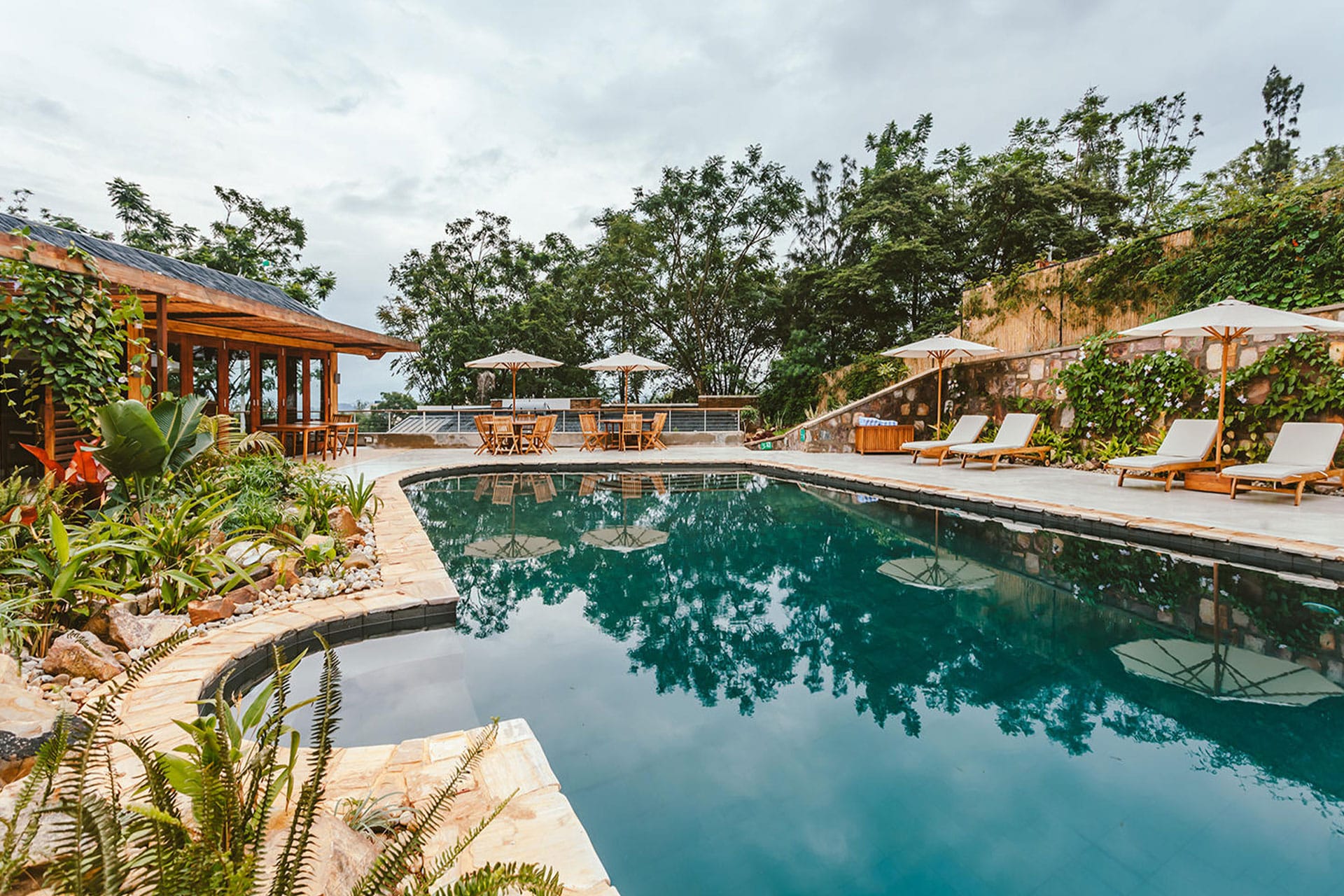 A pool with sun loungers at The Retreat