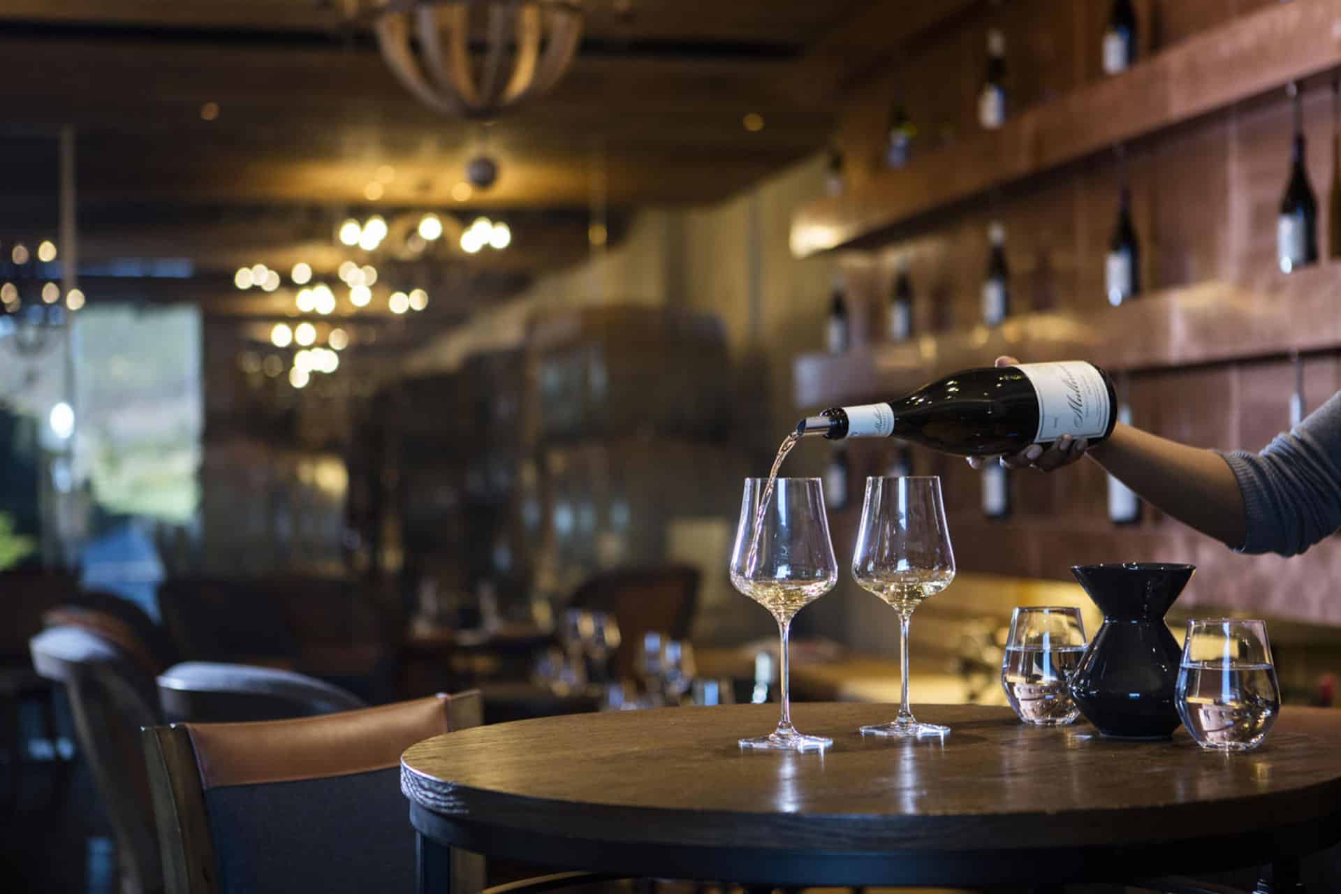 Wine being poured into a glass inside The Wine Studio at Leeu Estates