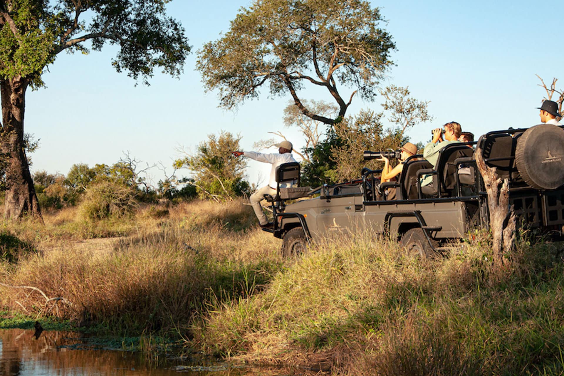 A tracker points to something from an electric safari vehicle in the Sabi Sands Game Reserve in South Africa.