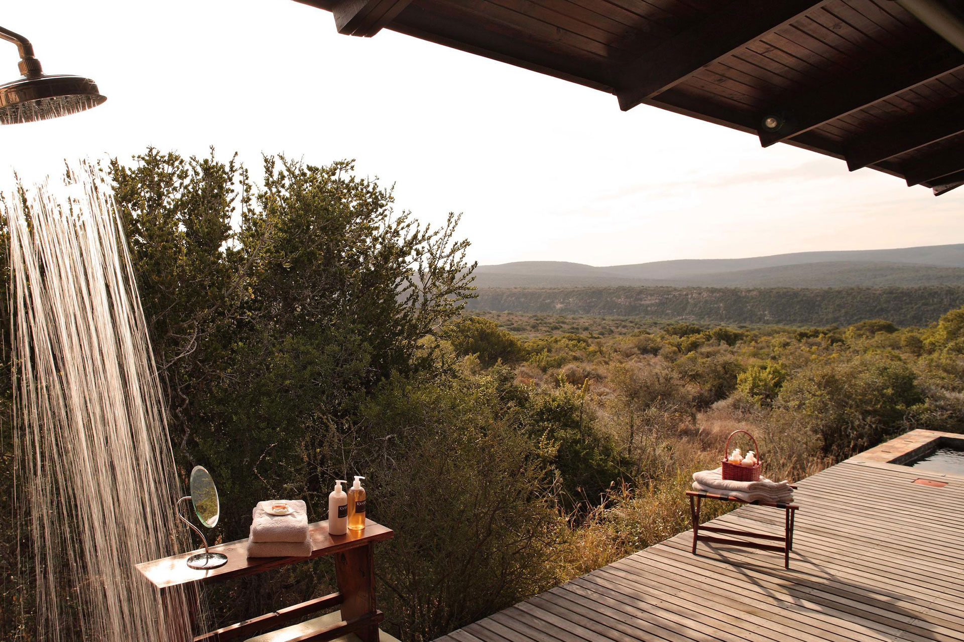 An outdoor shower on a wooden deck overlooking the bush at Ecca Lodge in Kwandwe Private Game Reserve.