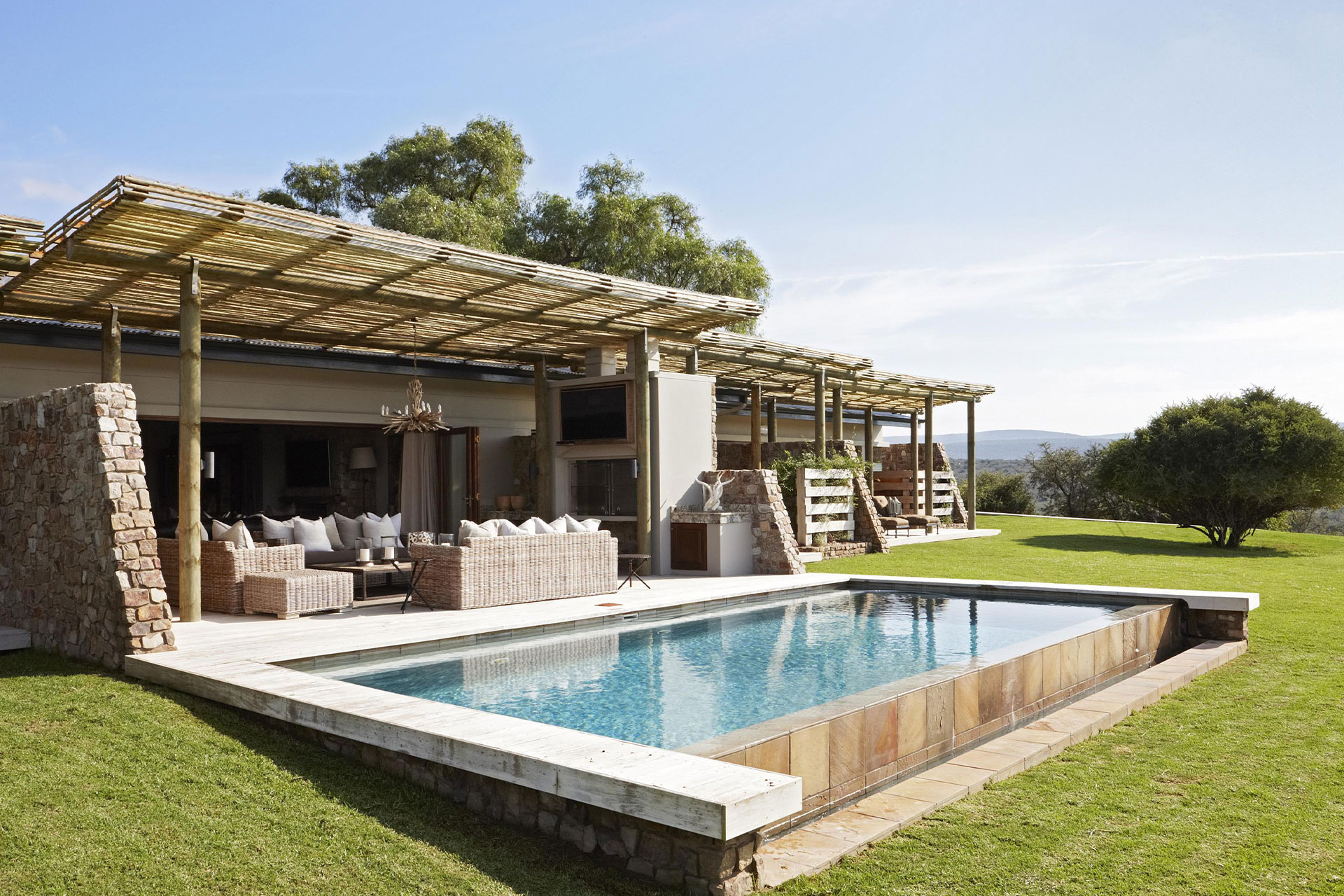 Outdoor seating and the pool at the Old Fort House at Kwandwe Private Game Reserve. 