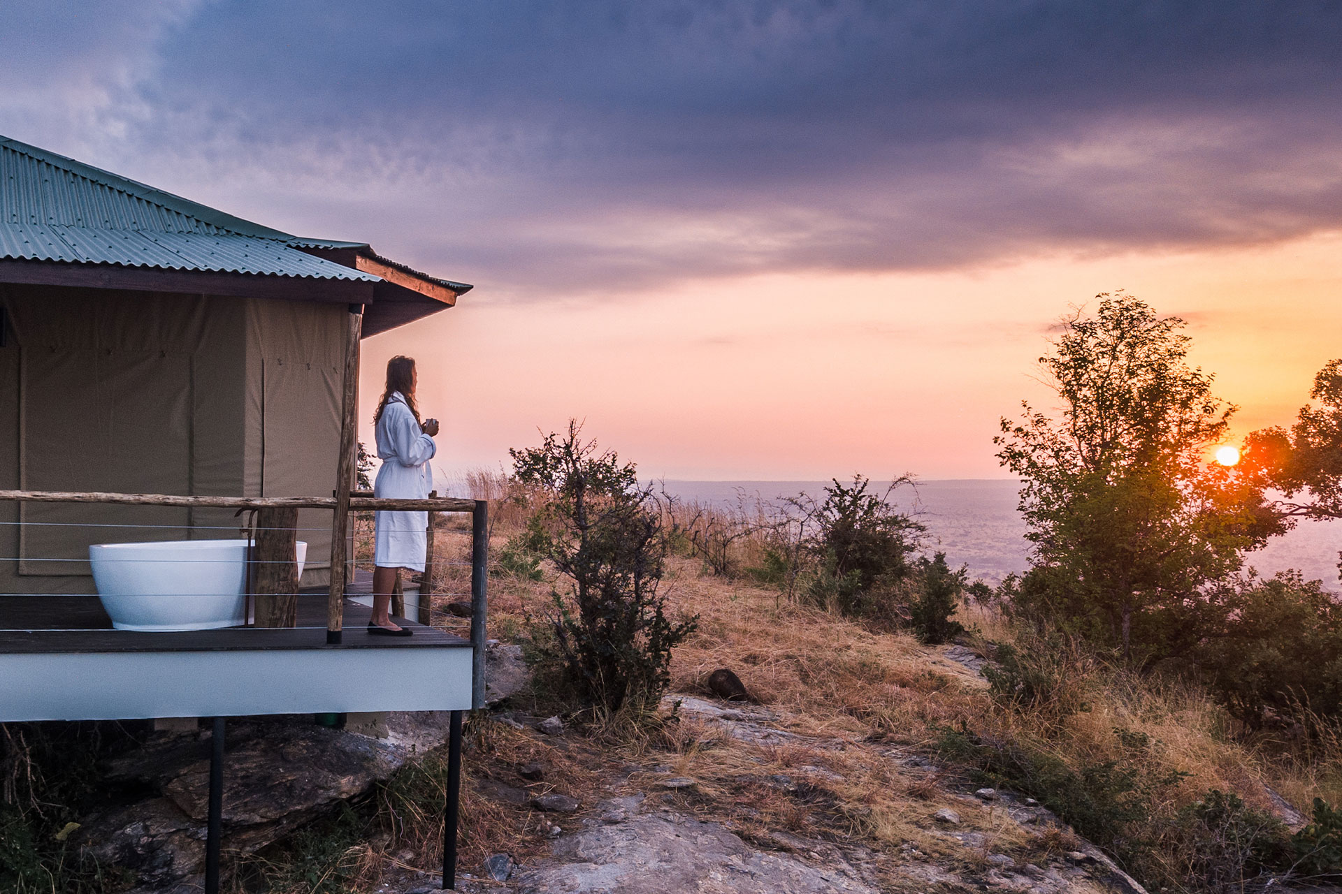 An outdoor bath and sunken lodge on a wooden deck with views of the Tarangire National Park at Lemala Mpingo Ridge Lodge &ndash; a luxury lodge in East Africa. 