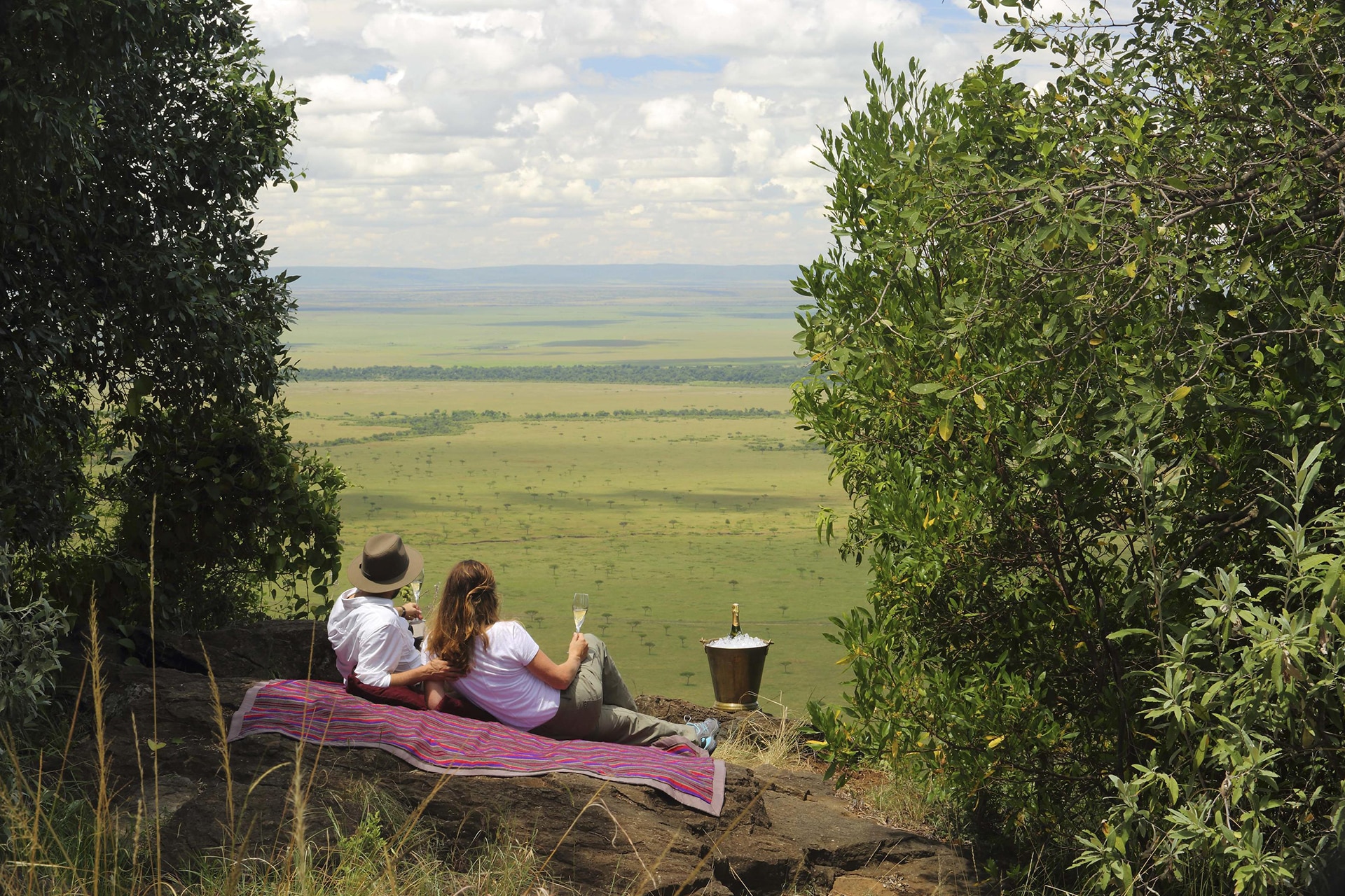 A couple having a picnic in the Maasai Mara &ndash; a recommended destination for honeymoons in Africa. 