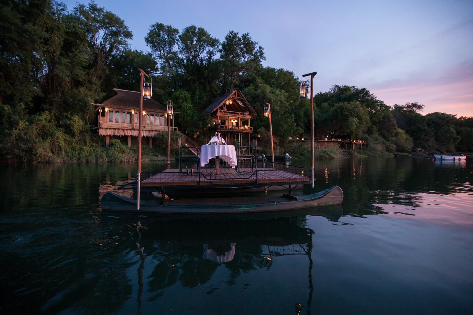 Dinner set up on a sampan on the Zambezi River at Tongabezi &ndash; a recommended destination for honeymoons in Africa