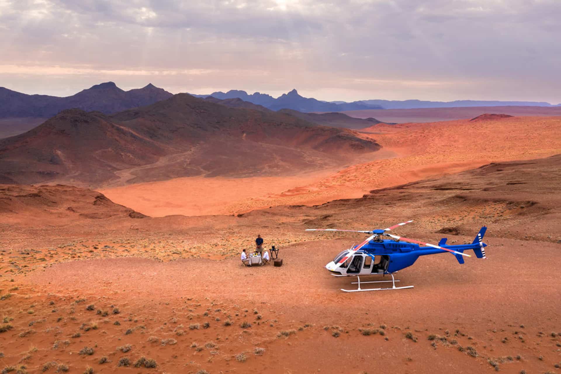 A romantic champagne picnic during a scenic helicopter flip over the desert &ndash; a recommended experience for honeymoons in Africa.