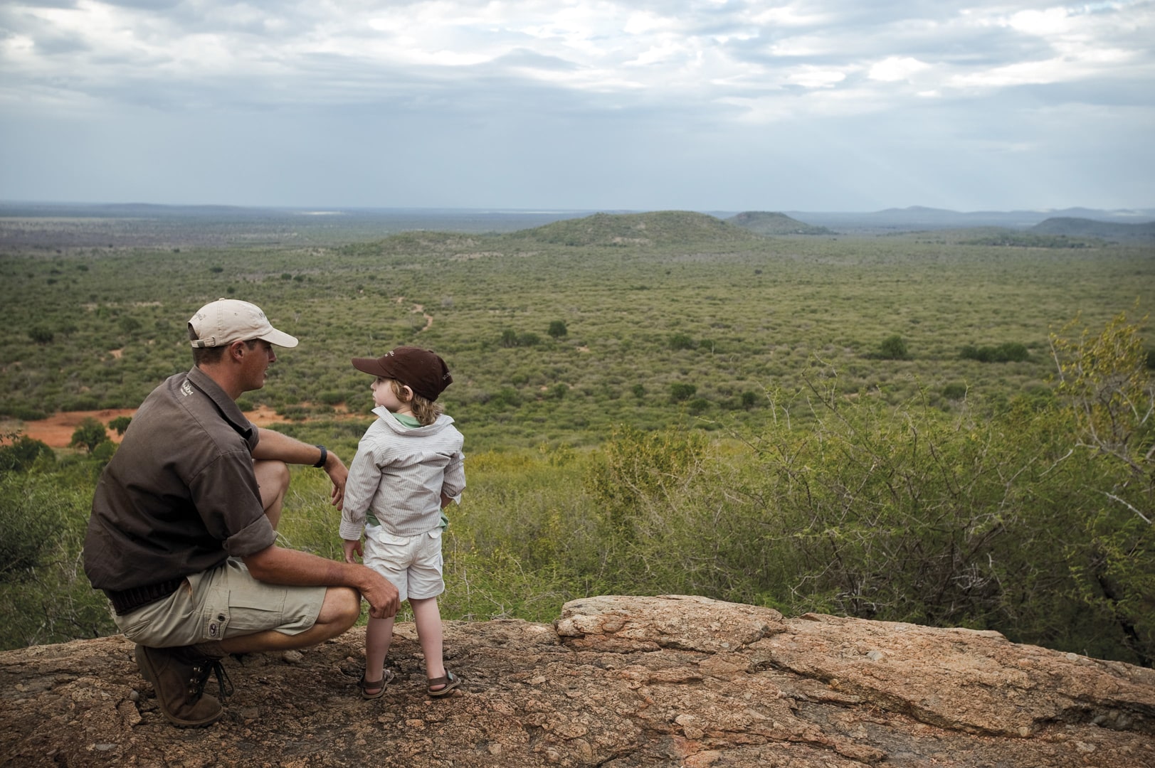 A ranger and a child looking out into the bush at Madikwe Hills Private Game Lodge &ndash; one of Southern Africa&rsquo;s best family friendly lodges.