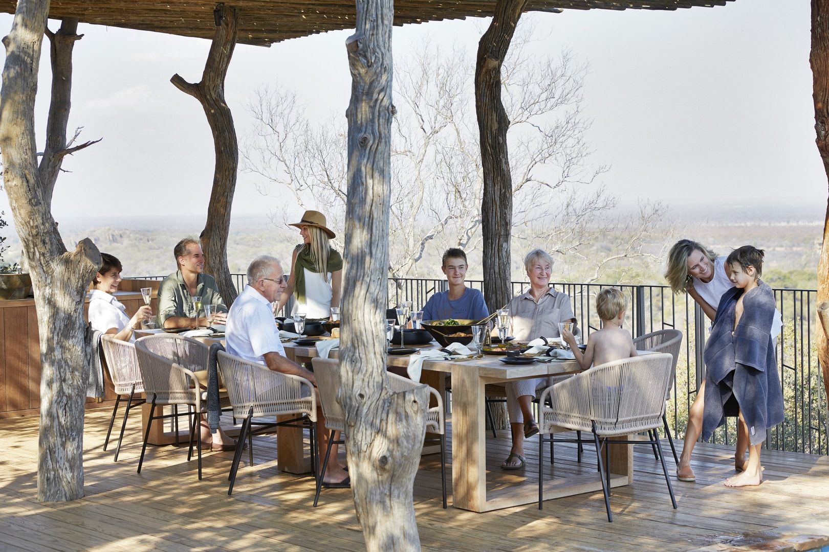 A family dining on the deck at Singita Malilangwe House &ndash; one of Southern Africa&rsquo;s best family friendly lodges.