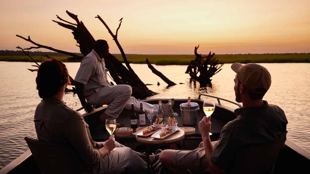 One couple having a sunset dinner on the river Chobe National Park, Sanctuary Chobe Chilwero in Botswana.
