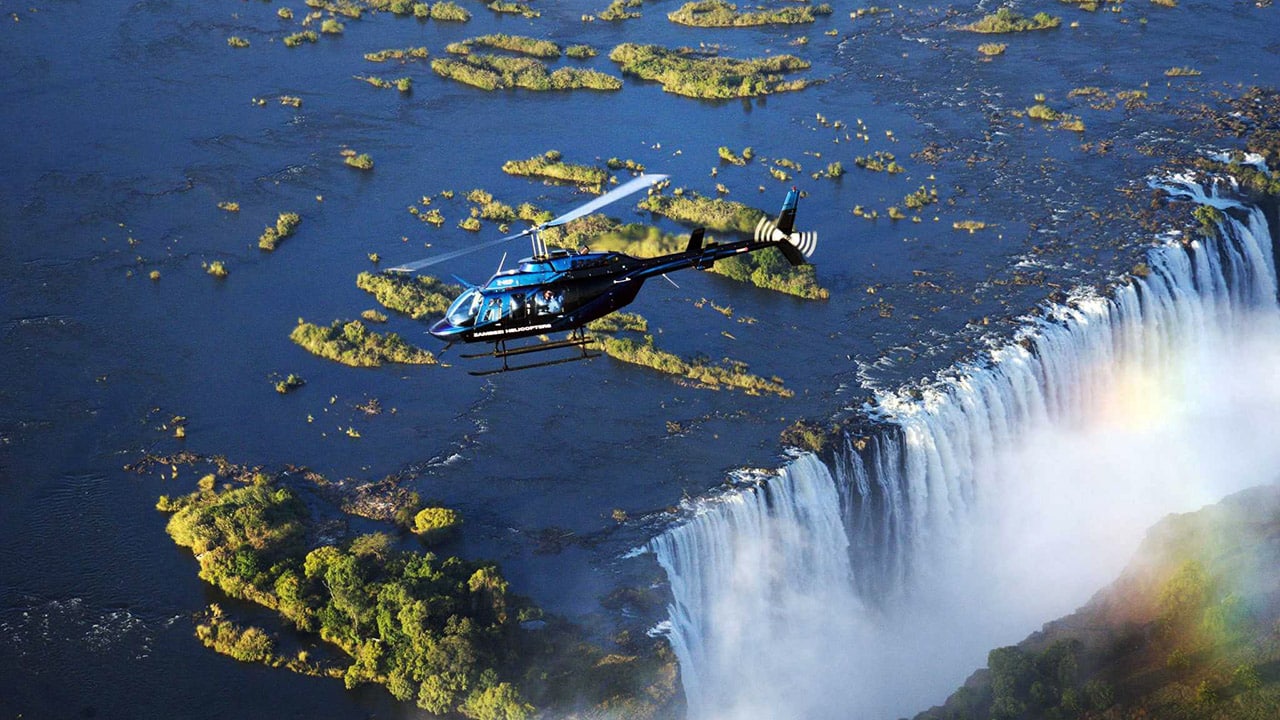 Helicopter flying over waterfalls with Ker & Downey Africa