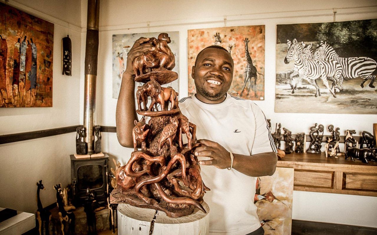 An artist in residence with his woodwork at Gibb&rsquo;s Farm with Ker & Downey&reg; Africa