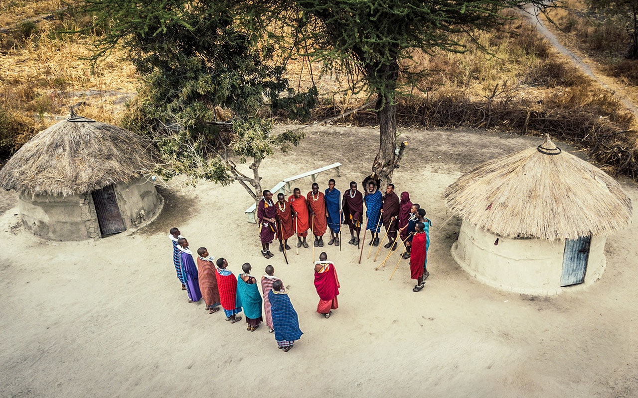 Maasai people standing inside their traditional boma with Ker & Downey&reg; Africa